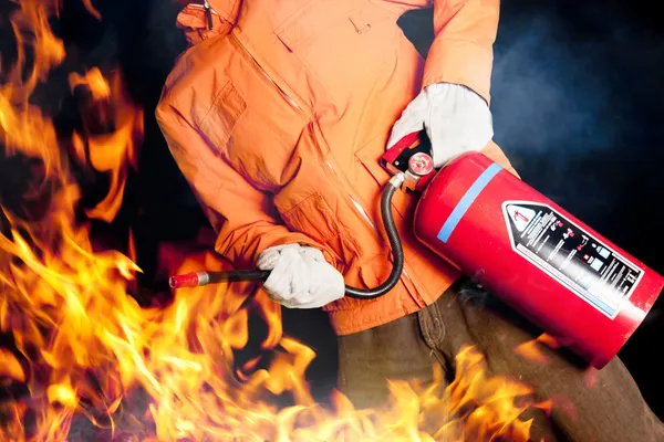 Feuerwehrmann bekämpft wütenden Brand mit großen Flammen — Stockfoto