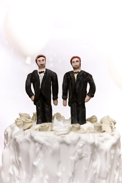 Miniatűr homoszexuális pár állandó tetején egy esküvői torta. — Stock Fotó