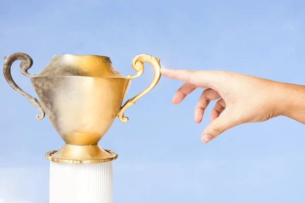 stock image Fingertip turns a vintage vase into gold