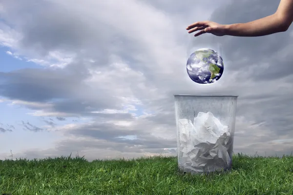 Earth being dropped in the trash — Stock Photo, Image