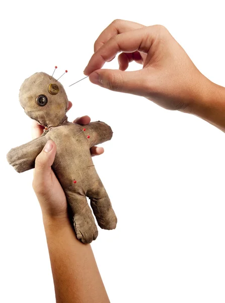 Mani in mano raccapricciante bambola voodoo con aghi isolati su bianco — Foto Stock