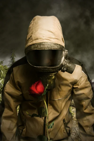 Man in a gas mask with a rose — Stock Photo, Image