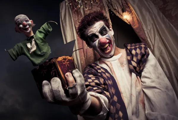 Фото страшного клоуна, держащего игрушку Джека в коробке — стоковое фото