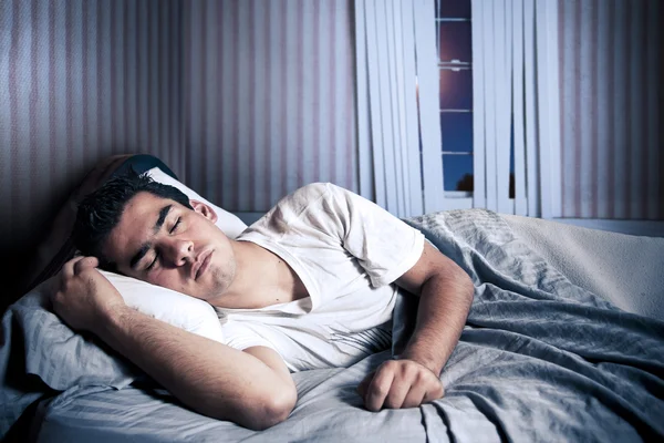 Mężczyzna śpi wygodnie w swoim łóżku. — Zdjęcie stockowe