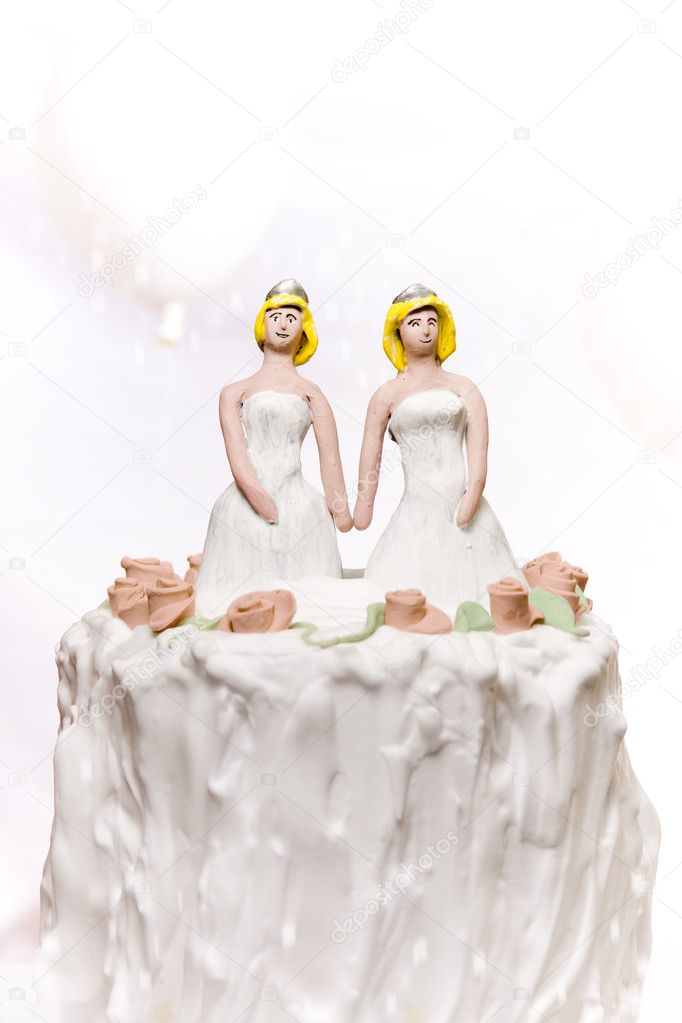 Miniature Lesbian couple standing on top of a wedding cake.