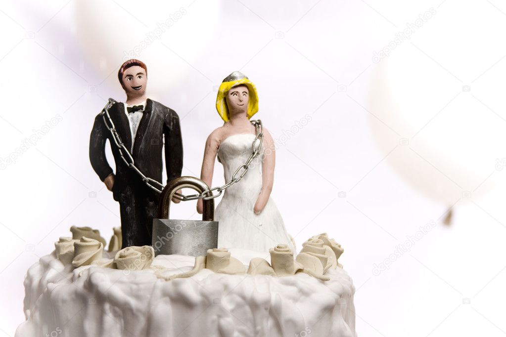 Figurines on top of wedding cake with padlock