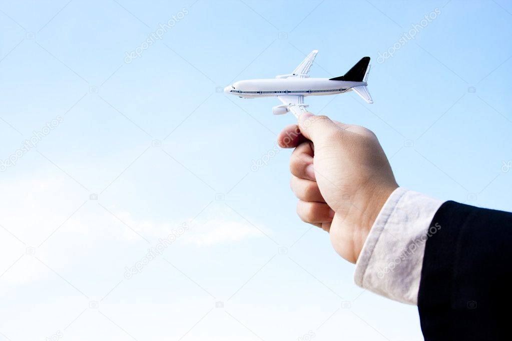 Businessman playing with a toy plane