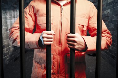 Inmate inside dark prison cell at night clipart