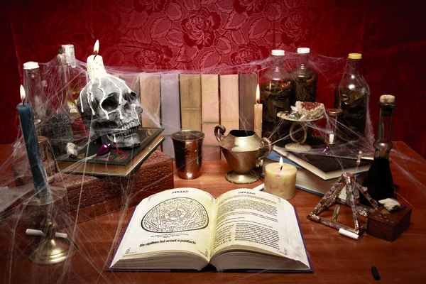 Table full of witchcraft related objects and cobwebs — Stock Photo, Image