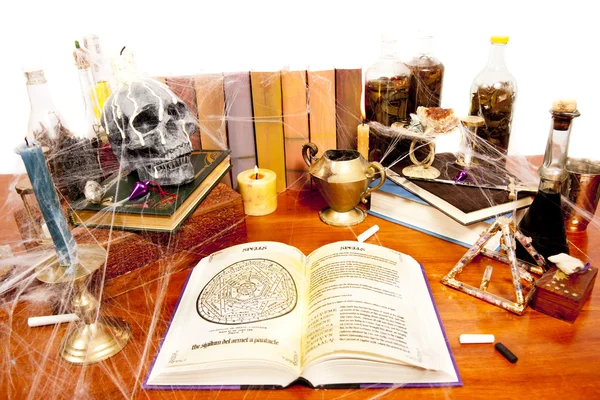 Mesa llena de objetos relacionados con la brujería y telarañas aisladas en blanco — Foto de Stock