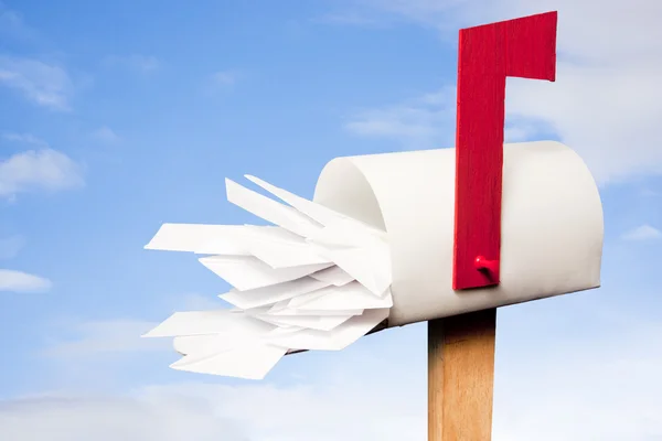 Mail box overflowing with mail against sky — Stock Photo, Image