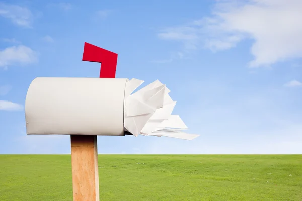 stock image Mail box overflowing with mail against sky and grass