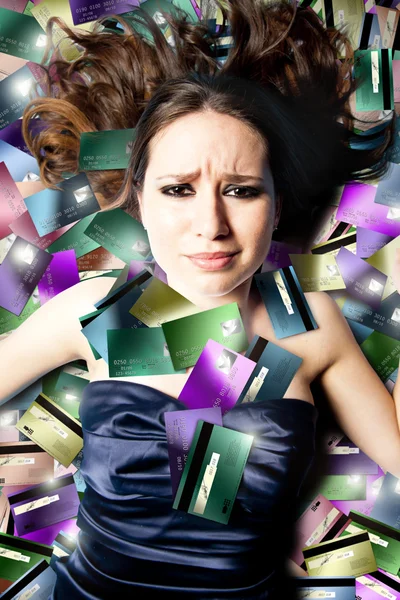 Troubled woman lying on credit cards — Stock Photo, Image