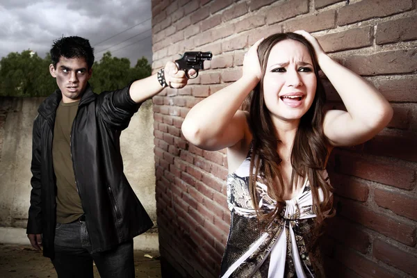 Voleur pointant une arme sur la tête d'une femme — Photo