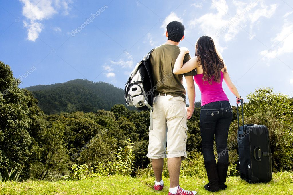 Beautiful Couple looking afar from the top of a mountain