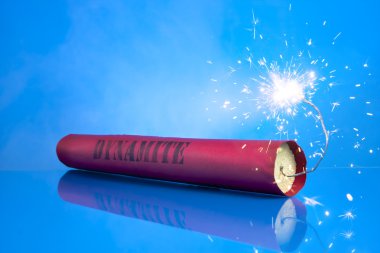 Lit dynamite stick on a blue background clipart