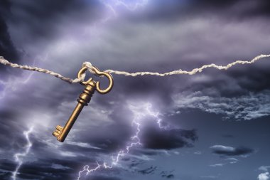Old key attached to a kite flying in a storm clipart