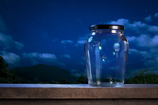 Fireflies in a jar at night — Stock Photo, Image