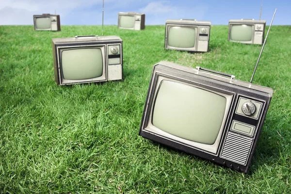 Field of grass with retro tv's — Stock Photo, Image