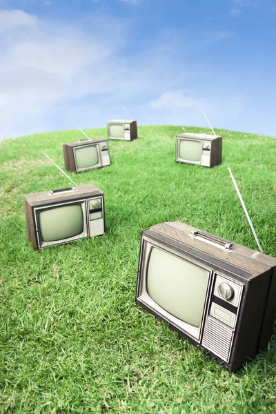 Field of grass with retro tv's — Stock Photo, Image
