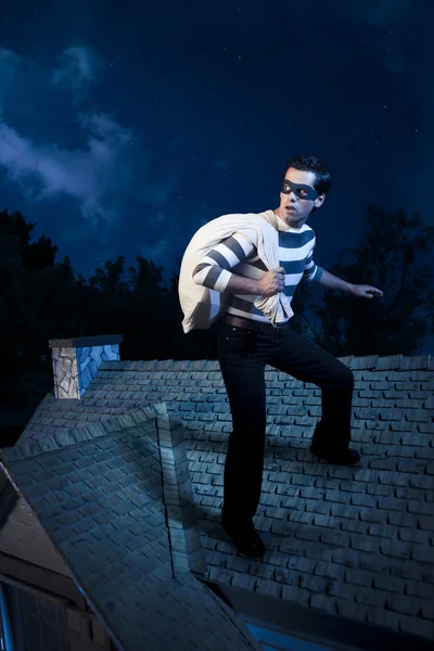 Ladrón caminando en el techo de una casa por la noche —  Fotos de Stock