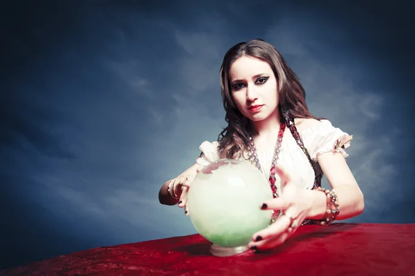 Pretty fortuneteller with her crystal ball on a seance sesion — Stock Photo, Image