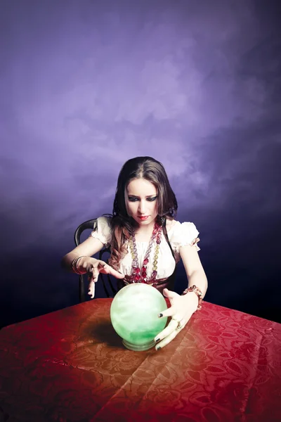 Pretty fortuneteller with her crystal ball on a seance sesion — Stock Photo, Image