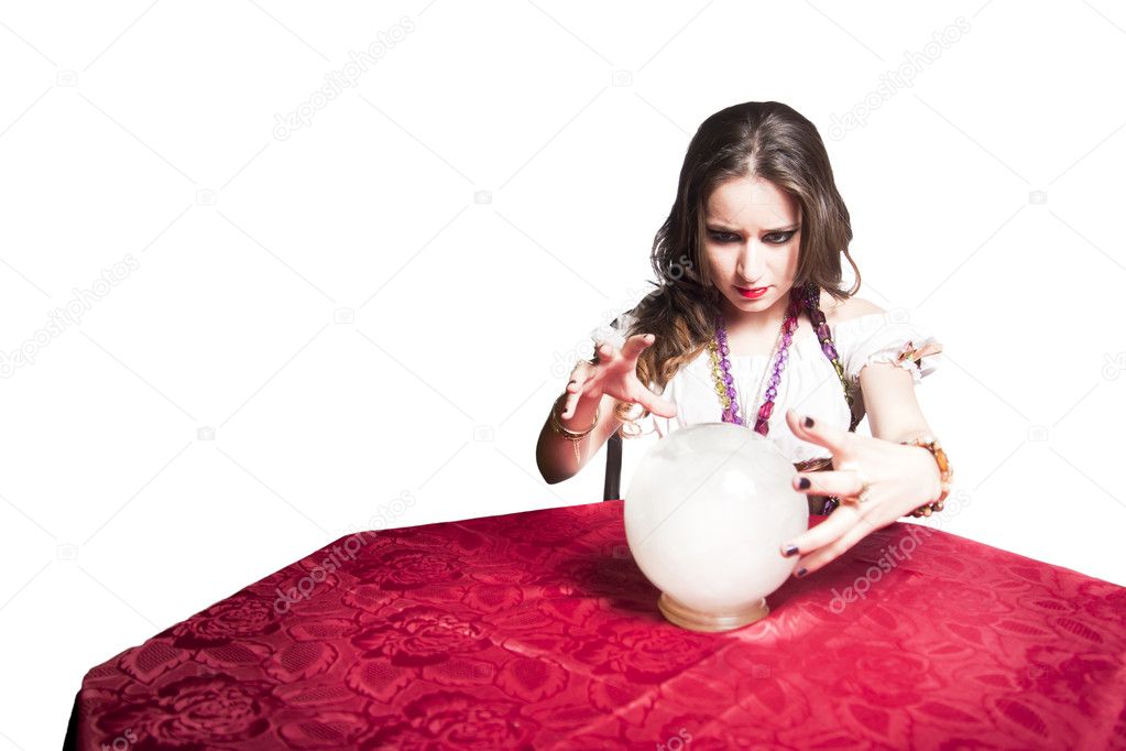 Pretty gypsy woman with her crystal ball predicting the future isolated on white