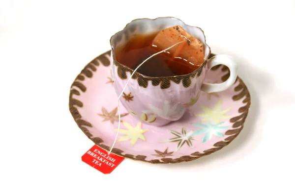 Antique cup with tea bag. — Stock Photo, Image