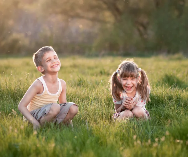 Веселые детишки в траве — стоковое фото
