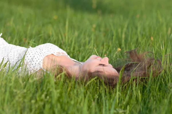 Beautiful healthy Young Woman lying on the green grass — Stock Photo, Image