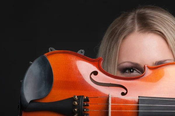 Girl holding a violin and looking through it — Stock Photo, Image