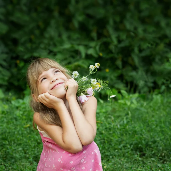 Девочка сидит в траве и мечтает — стоковое фото