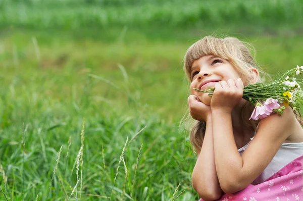 小さな女の子は牧草地に座っています。 — ストック写真