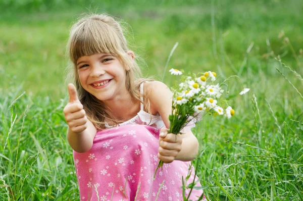 Het meisje is in het gras zitten en glimlachen — Stockfoto