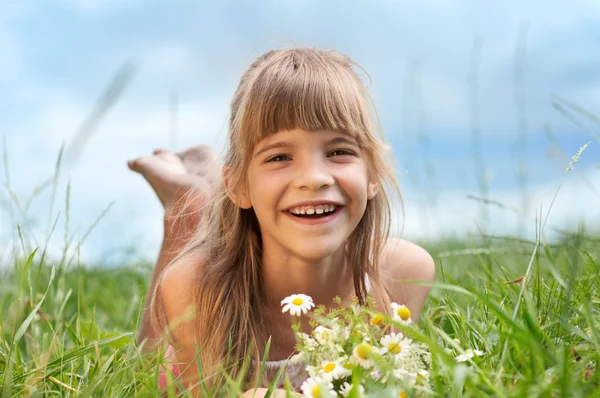 Das lachende Mädchen liegt auf dem Gras — Stockfoto