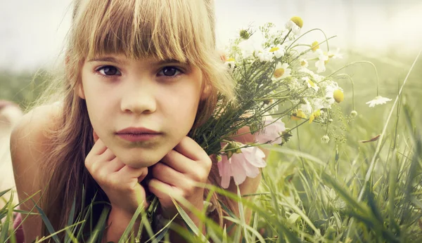 The little girl is lying in the meadow — Stock Photo, Image