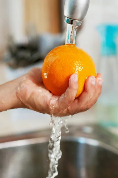 L'arancia viene lavata nell'acqua — Foto Stock