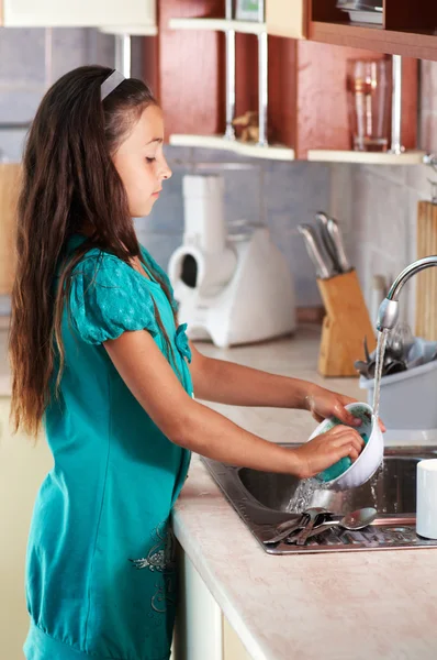 Ragazza che lava i piatti in cucina — Foto Stock