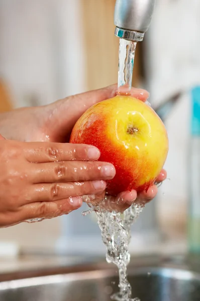 A maçã está sendo lavada na água — Fotografia de Stock