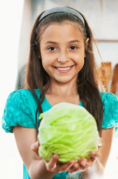 The girl is holding the cabbage — Stock Photo, Image