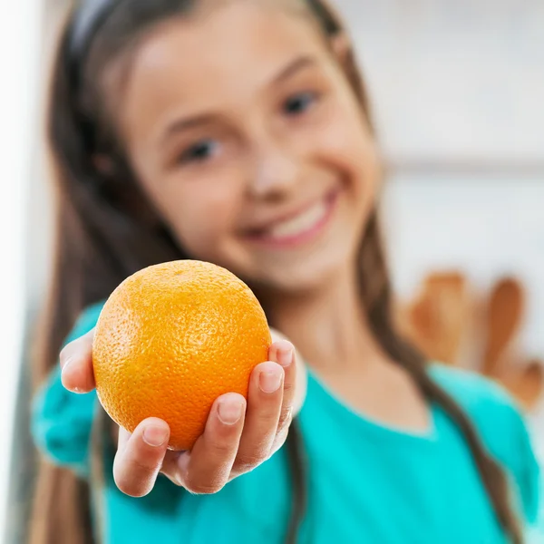 The girl is holding the orange — Stock Photo, Image