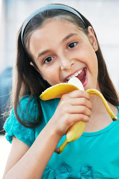 Söt flicka äter en banan — Stockfoto