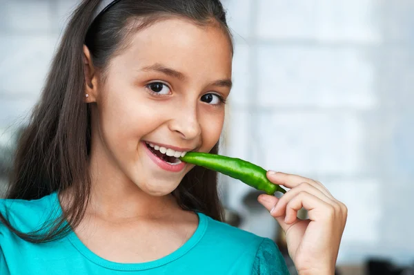 Leuk meisje eet een peper — Stockfoto