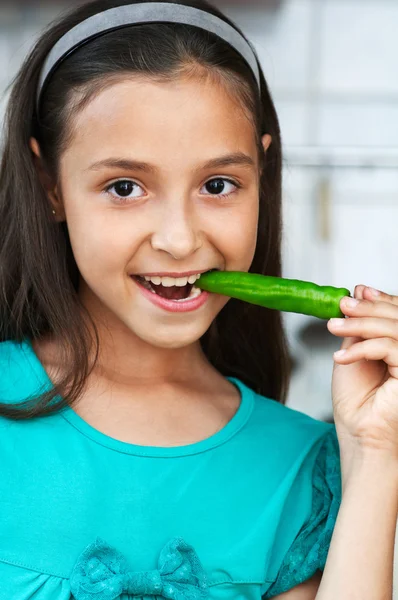 Ragazza carina mangia un pepe — Foto Stock