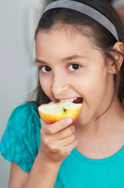 Söt flicka äter ett äpple — Stockfoto