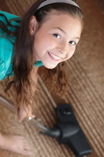 La ragazza sta aspirando il tappeto. — Foto Stock