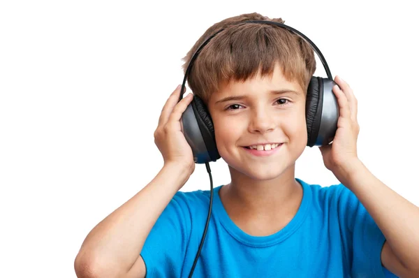 El chico sonríe y escucha música. — Foto de Stock