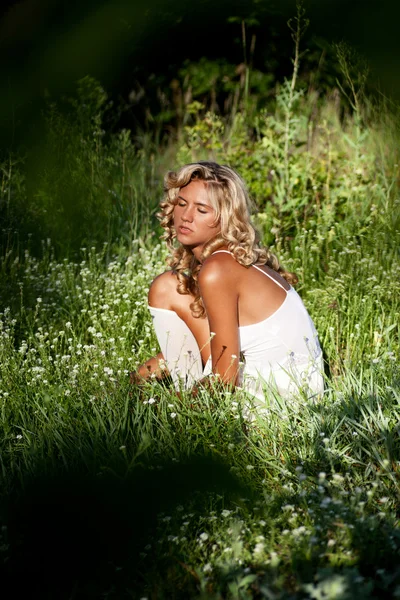 Chica en vestido blanco caminando en el prado en el día de verano —  Fotos de Stock