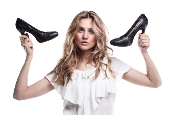 Fashion studio shot of shopping girl holding a black high heel s — Stock Photo, Image